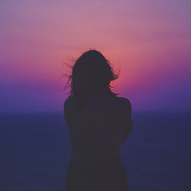 silhouette of woman reflecting during sunset